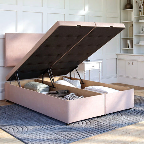 Pink upholstered bed with storage compartments in a room with white walls and a rug.